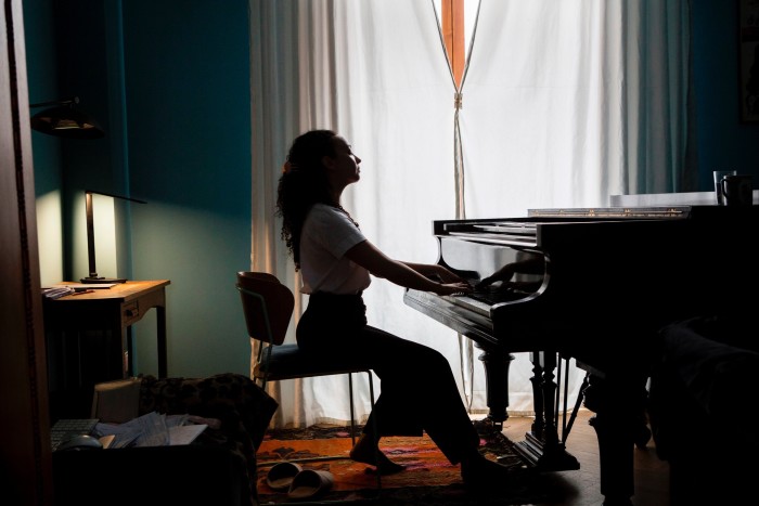 Nadia Beard sits at a grand piano in her flat in Tblisi