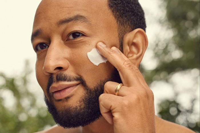 A man rubs cream on his face