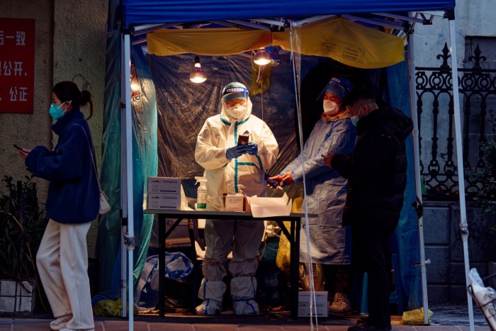 Covid-19 tests are administered in a street booth in Shanghai
