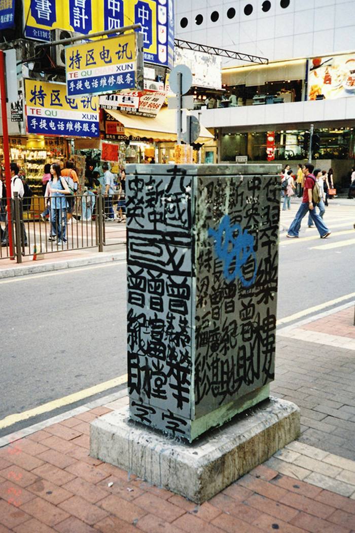 A metal box on a public street has been covered in Chinese writing
