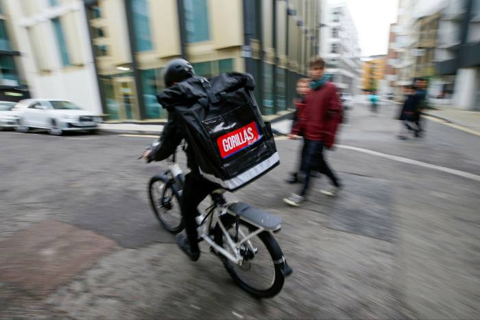 A bicycle delivery courier for Gorillas collects orders from their warehouse in Shoreditch in London in May 2021