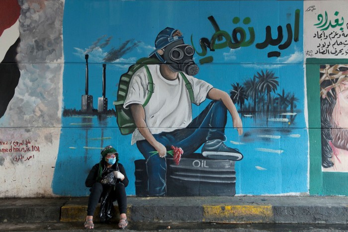 A protester sits in front of a mural that reads, ‘I want my oil’, in Baghdad. If Iraq — which has 145bn barrels of proven crude reserves — stays dependent on oil, its finance minister says, ‘it could be catastrophic’
