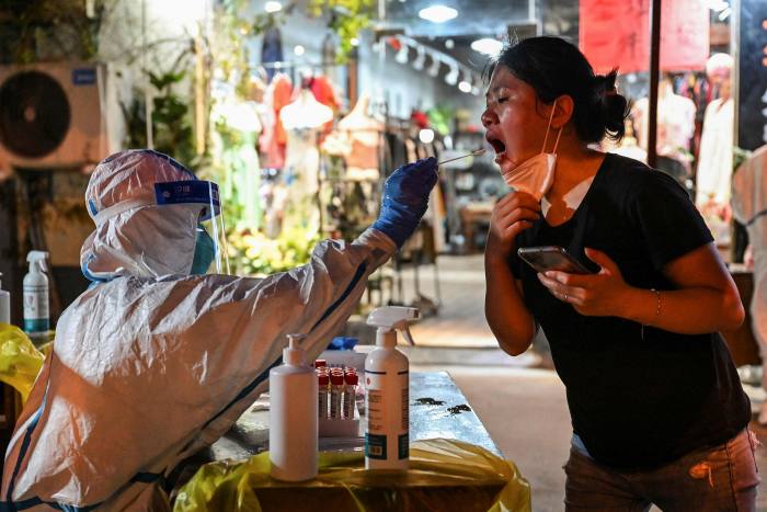 A health worker takes a swab sample in Shanghai