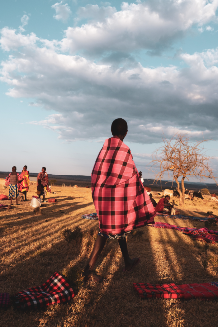Un Masaï porte une couverture rouge autour de ses épaules et de son corps 