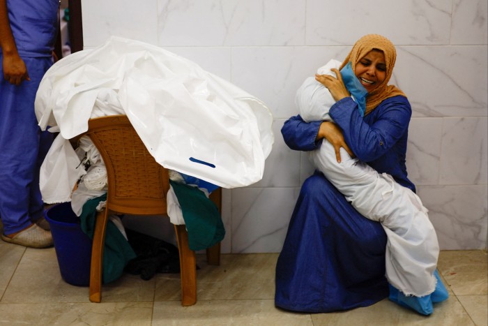 A woman embraces the body of a Palestinian child killed in Israeli strikes, at a hospital in Khan Younis in the southern Gaza Strip
