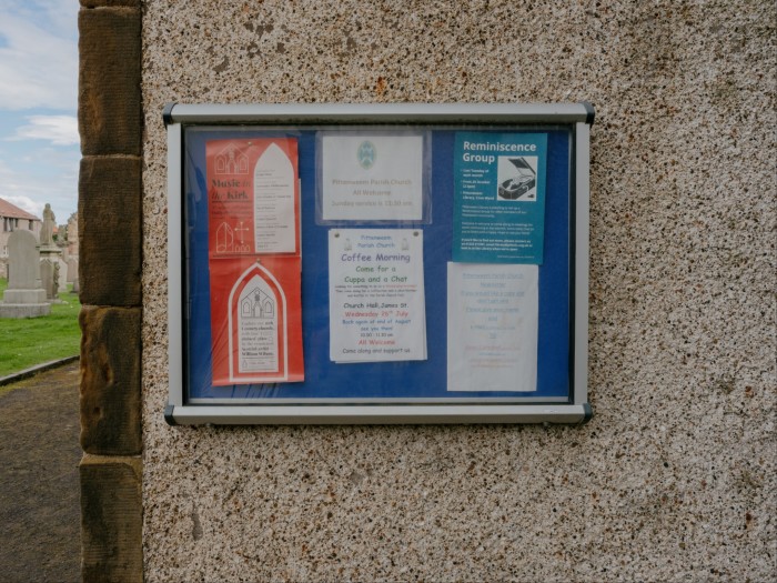 A noticeboard on a wall contains information about coffee mornings, reminiscence groups and so on 