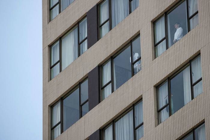 A man looks out of his window in a government-designated quarantine hotel in Hong Kong