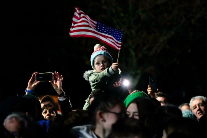A child waves an American flag as President Joe Biden speaks outside St Muredach’s Cathedral in Ballina