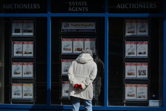 A woman looks at the local estate agent’s window in Dublin 