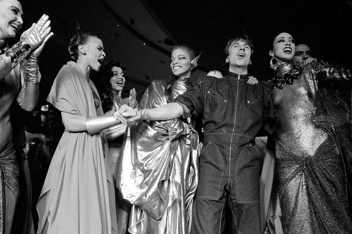 French fashion designer Thierry Mugler celebrates with models after his show in New York in 1980. His designs helped define the decade