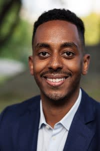 Outdoor close-up portrait of Michael Takabe in a collared shirt and smart jacket