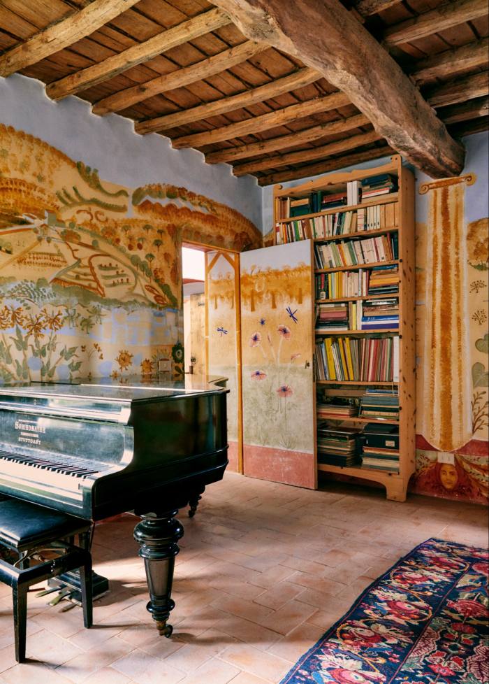 Bilik piano dengan alang terdedah, lantai berjubin dan rak buku kayu tinggi