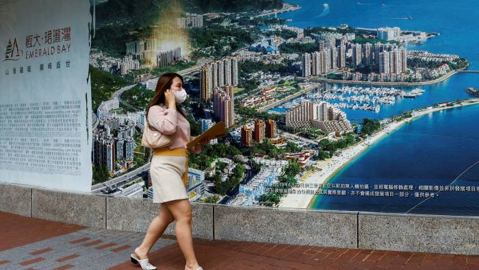 A woman walks past a property advertisement for Emerald Bay by China Evergrande in Hong Kong