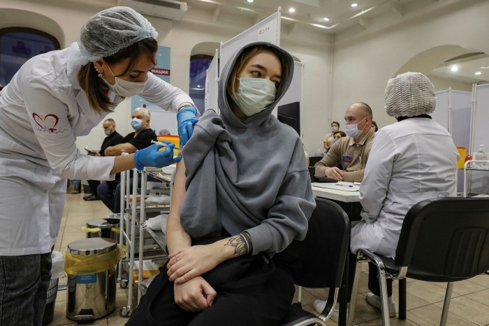 A woman receives a shot of Russia’s Sputnik V vaccine