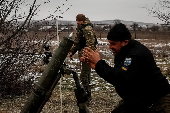 Ukrainian servicemen fire a mortar toward Russian positions on a frontline near the town of Soledar in Donetsk region