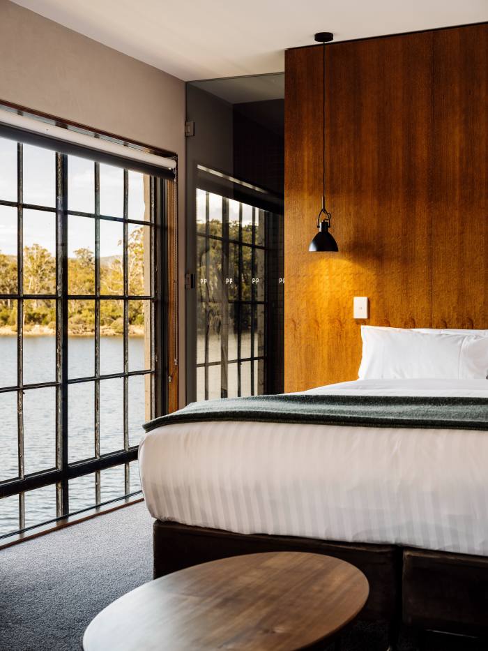 A bedroom with a view of the lake at Pumphouse Point