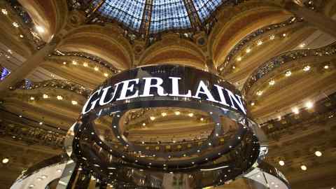 A Guerlain logo above a sales stand in a store