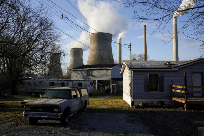A home stands in front of a power plant in West Virginia. In the US, coal-fired power generation was higher in 2021, under Joe Biden, than it was in 2019 under Donald Trump