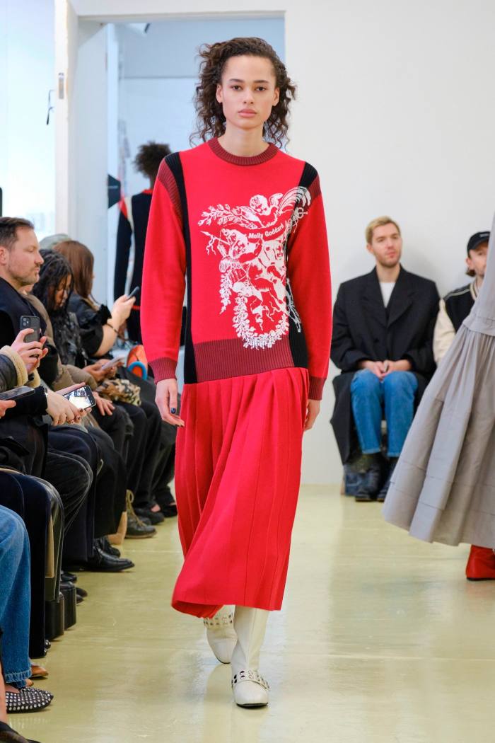 A model on a catwalk in sweater-top dress