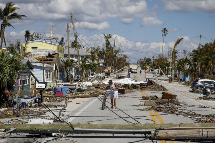 A resident walks past debris on Pine Island Road following Hurricane Ian in Matlacha Isles, Florida