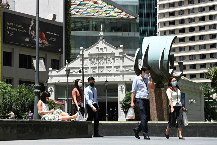 Pedestrians wear masks in Singapore’s Raffles Place financial district