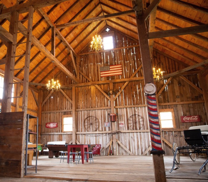 The interior of a vast renovated 1796 barn with exposed timber beams and struts