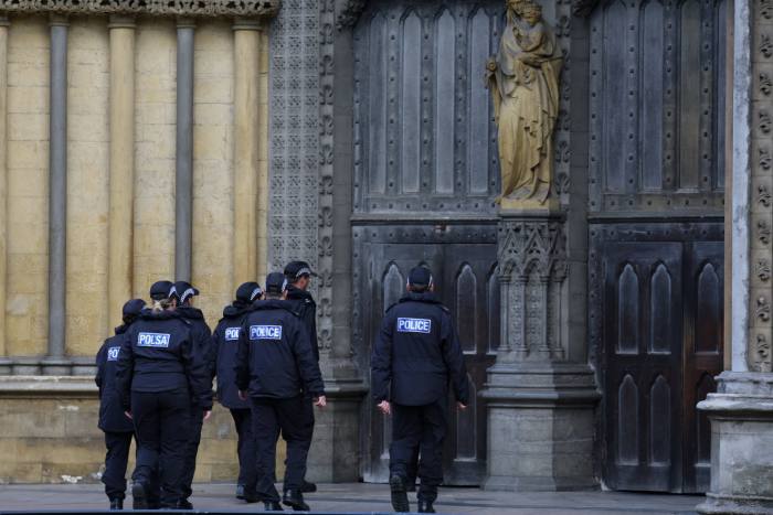 Un equipo de búsqueda de la policía ingresa a la Abadía de Westminster antes del funeral de la reina Isabel II el lunes.