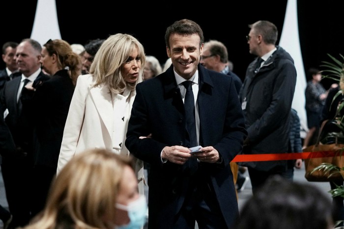 Emmanuel Macron and his wife Brigitte wait to vote at a polling station in northern France on Sunday