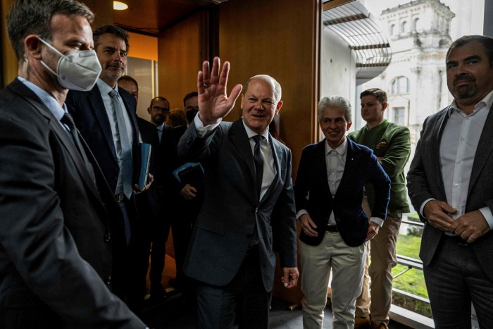 German Chancellor Olaf Scholz waves as he leaves the Bundestag with Marie-Agnes Strack-Zimmermann,  chairwoman of the parliamentary committee on defence