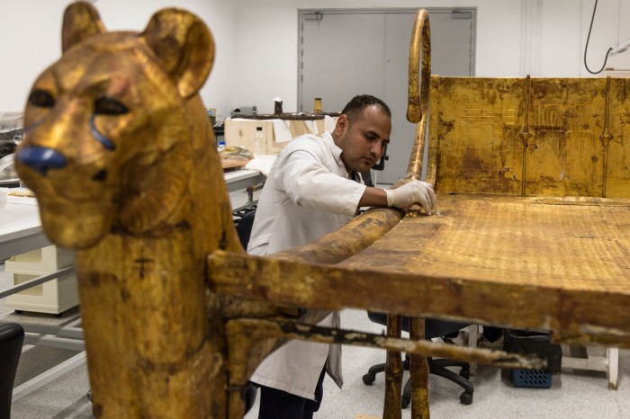 A conservationist works on one of King Tutankhamun’s beds at a laboratory in the Grand Egyptian Museum