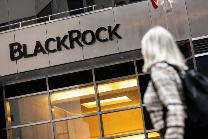 A woman walks past Blackrock headquarters in New York, US