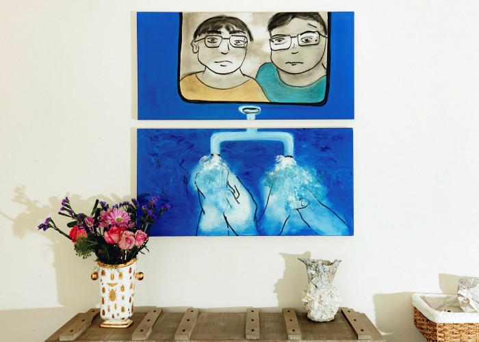 Φωτογραφία πίνακα ζωγραφικής σε οικιακό τοίχο.  Ο πίνακας δείχνει δύο άτομα να κοιτούν έξω και από κάτω δύο άτομα να πλένουν τα χέρια τους.  Υπάρχει ένα τραπέζι με ένα βάζο με λουλούδια από κάτω