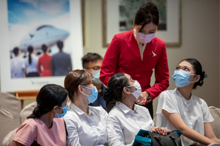 An employee speaks to applicants during a Cathay Pacific flight attendant recruitment event