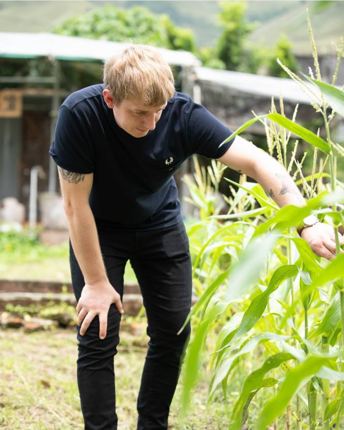 Roganic chef Ashley Salmon looking at crops on a farm visit