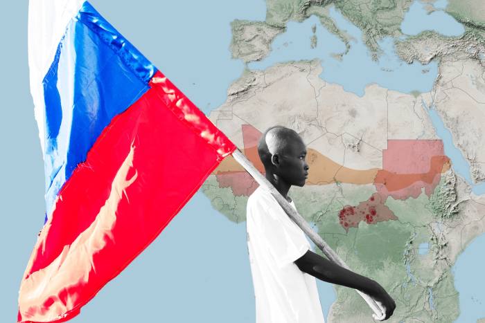 Person holding a Russian flag in front of map of Africa