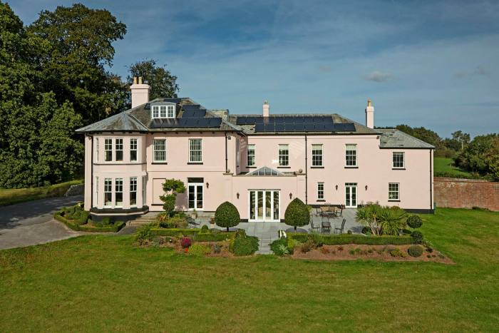 A Georgian country house surrounded by parkland-style lawns