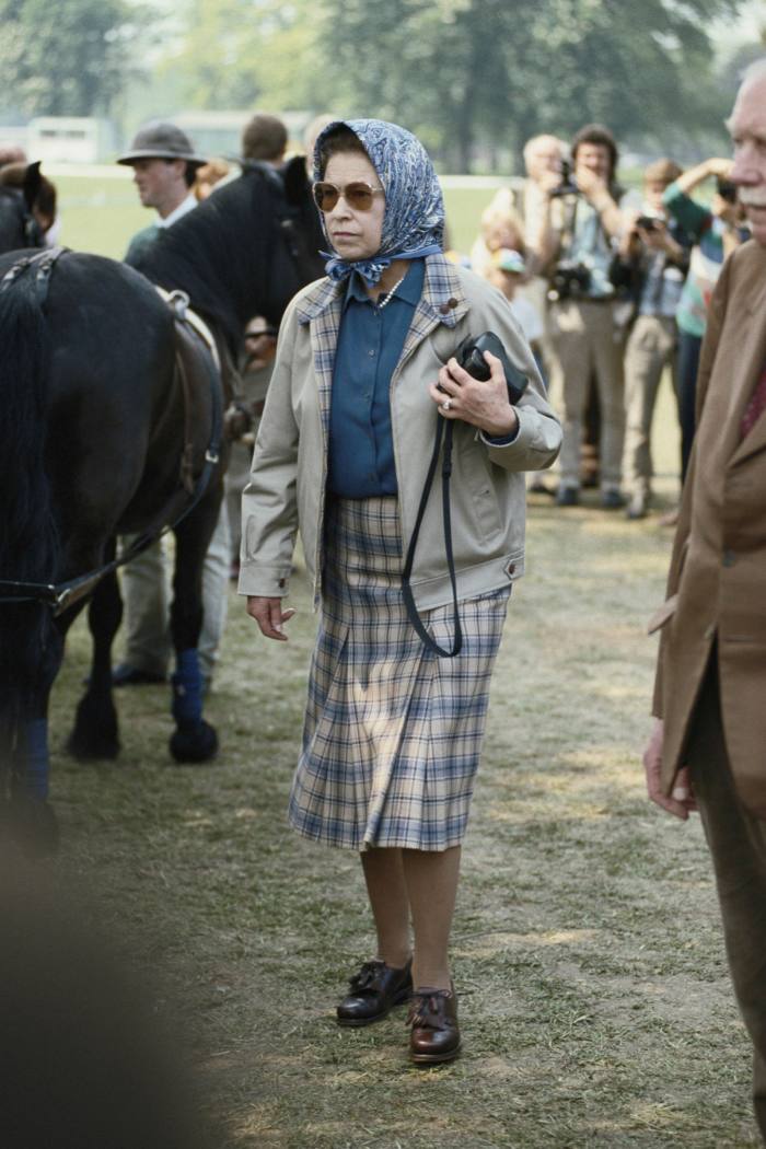 Queen Elizabeth II, wearing a headscarf and a tartan skirt, at the Royal Windsor Horse Show, held at Home Park in Windsor, Berkshire, England, Great Britain