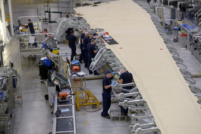 Employees work on a section of a wing on the Airbus A350 production line
