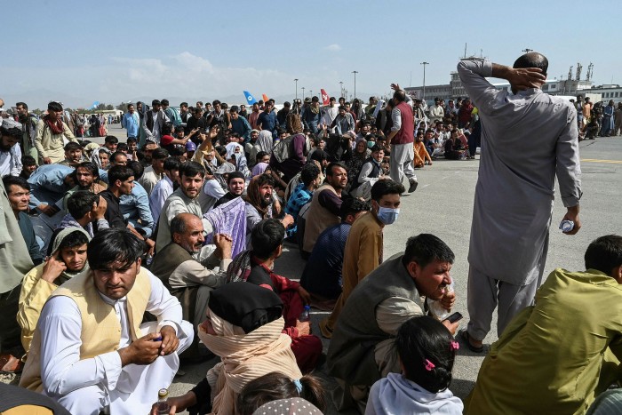 On August 16, Afghan passengers sitting while waiting to leave Kabul International Airport