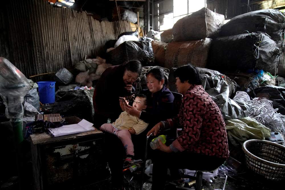 Watching the news on a mobile phone at a recycling station in Shanghai