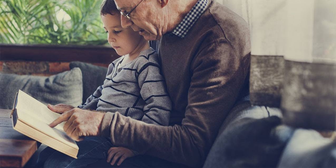 Grandfather reading to grandson