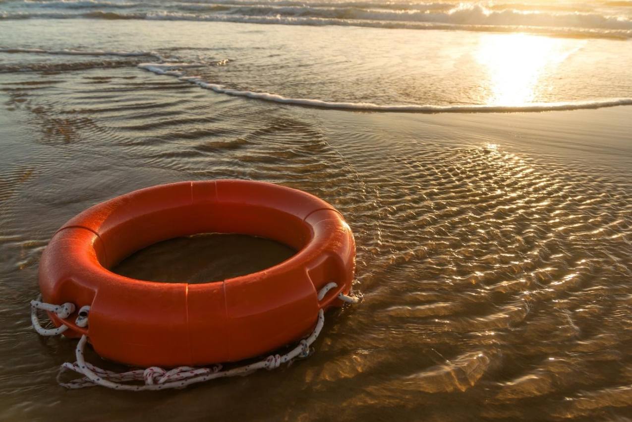 Life ring buoy on beach with waves