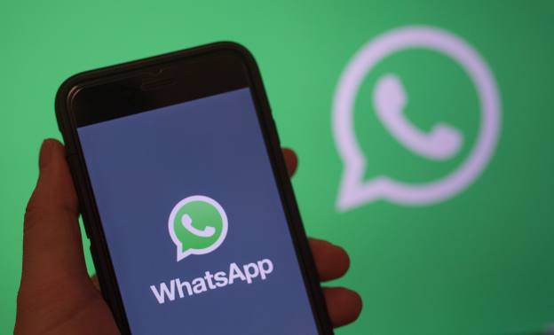 A smartphone screen displays the logo of the mobile application WhatsApp