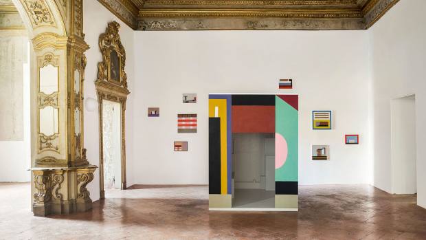 The A Palazzo show features a constellation of paintings around a wooden “cabin”