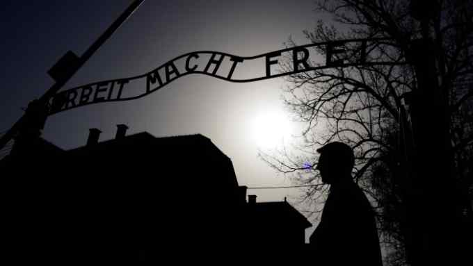 A man stands in front of the &quot;Arbeit macht frei&quot; (Work sets you free) gate in the former Nazi death camp Auschwitz, before the annual &quot;March of the Living&quot; to commemorate the Holocaust, in Oswiecim, Poland, April 12, 2018. REUTERS/Kacper Pempel - RC1C2388A5D0