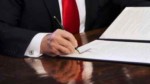U.S. President Donald Trump signs an Executive Order related to the review of the Dodd-Frank Act in the Oval Office of the White House, in Washington, D.C., U.S., on Friday, Feb. 3, 2017. Trump will order a sweeping review of the Dodd-Frank Act rules enacted in response to the 2008 financial crisis, a White House official said, signing an executive action Friday designed to significantly scale back the regulatory system put in place in 2010. Photographer: Aude Guerrucci/Pool via Bloomberg