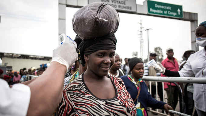 A woman gets her temperature measured at an Ebola screening station as she enters Rwanda from the Democratic Republic of the Congo on July 16, 2019 in Goma. - The first patient to be diagnosed with Ebola in the eastern DR Congo city of Goma has died, the governor of North Kivu province said on July 16, 2019. The case -- the first in a major urban hub in the region's nearly year-old epidemic of the disease -- has sparked deep concern in neighbouring Rwanda and at the UN. (Photo by JOHN WESSELS / AFP) (Photo credit should read JOHN WESSELS/AFP/Getty Images)