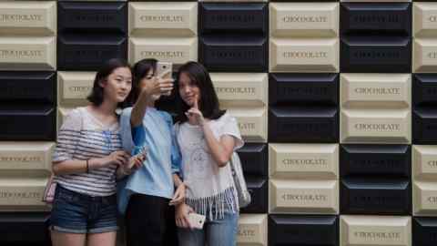 Young Chinese women take a selfie photo with a smartphone at a shopping mall complex in Beijing on August 9, 2016. China's producer prices fell at their slowest rate in nearly two years in July, the government said on August 9, a sign of improving conditions in the world's second largest economy. / AFP / NICOLAS ASFOURI (Photo credit should read NICOLAS ASFOURI/AFP/Getty Images)