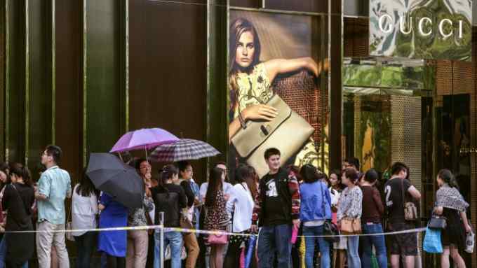 SHANGHAI, CHINA - MAY 27:  (CHINA OUT) Customers wait outside Gucci Store in Golden Eagle Shopping Center on Shanxi North Road to enjoy Gucci's 50% discount on May 27, 2015 in Shanghai, China. It was said that luxuries as Chanel, Cartier had cut price in China before and Gucci had also reduced their price of most articles with fifty percent discount in China on May 27.  (Photo by VCG/VCG via Getty Images)