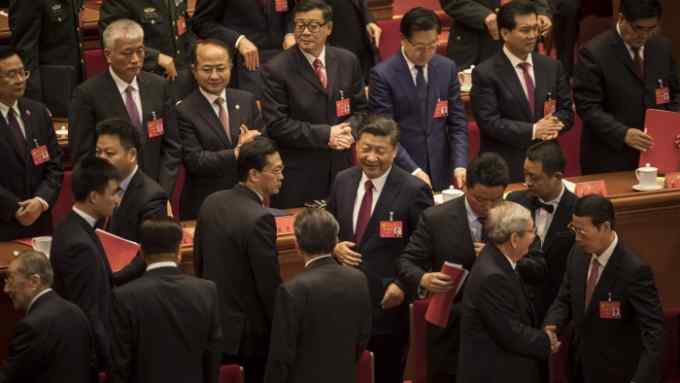 Xi Jinping, China's president, center, and delegates stand at the conclusion of the closing session of the 19th National Congress of the Communist Party of China at the Great Hall of the People in Beijing, China, on Tuesday, Oct. 24, 2017. China's ruling Communist Party approved a revised charter that enshrined Xi's&nbsp;name under its guiding principles, elevating him to a status that eluded his two immediate predecessors. Photographer: Qilai Shen/Bloomberg
